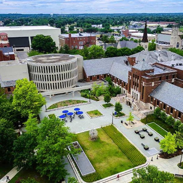 Aerial shot of campus in summertime, with Parsons Hall and Tirey Hall visible, along with part of the quad. Many other buildings are visible in the background.